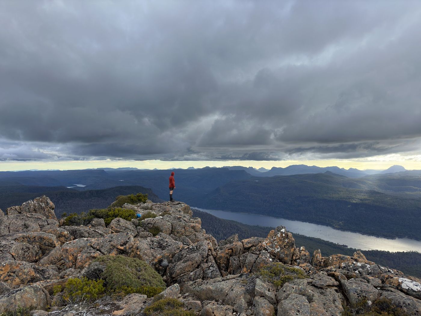 A walker on the rocks of Clumner Bluff, above a lake